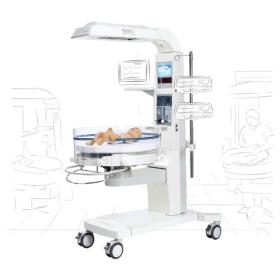  A specialized baby warmer in a hospital setting, designed to provide gentle and regulated heat to newborn infants. The warmer consists of a clear, enclosed bed where the baby is placed, with integrated temperature controls and monitoring equipment to ens